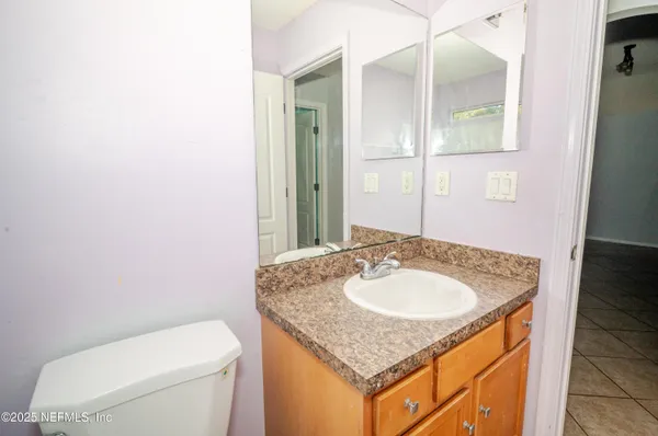 a bathroom with a granite countertop sink and a mirror
