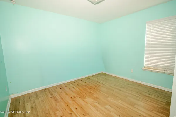 a view of a room with wooden floor and a window