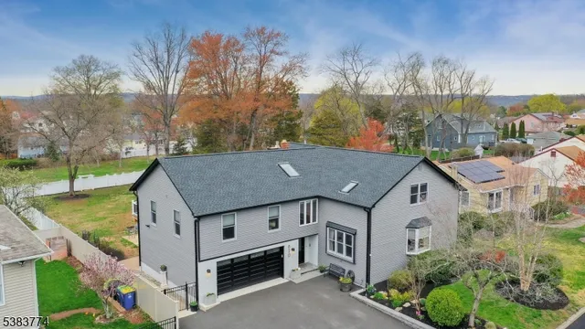 a aerial view of a house in a big yard with large trees