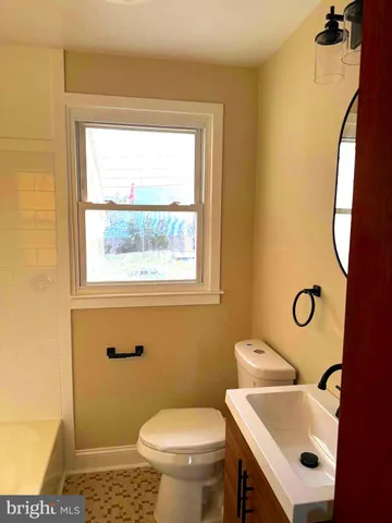 a bathroom with a sink toilet and a mirror