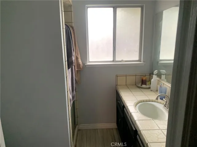 a bathroom with a granite countertop sink and a window