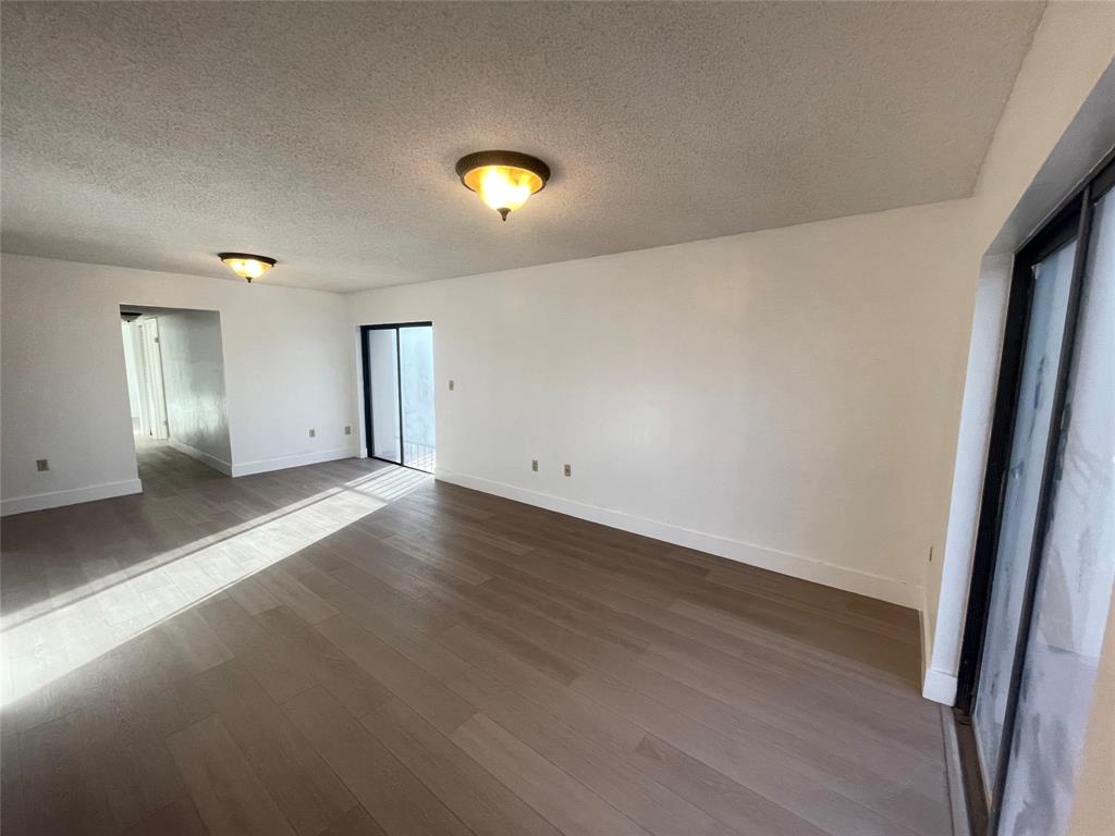 1470 West 41st Street, Unit 201 Hialeah, FL 33012 - Photo 6 of 26 an empty room with wooden floor and windows