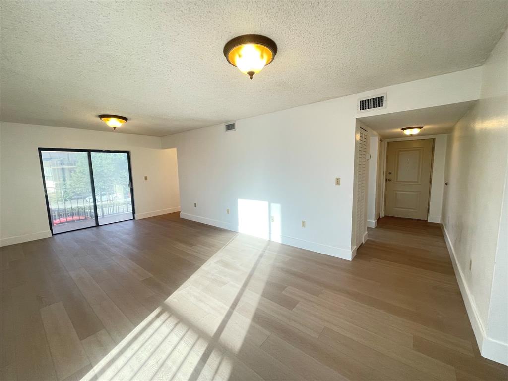 1470 West 41st Street, Unit 201 Hialeah, FL 33012 - Photo 8 of 26 a view of an empty room with wooden floor and windows
