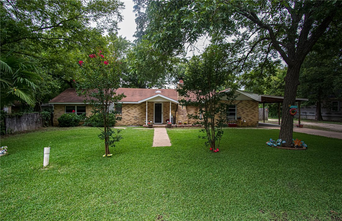 106 Ila Street Elgin, TX 78621 - Photo 1 of 1 a front view of house with a garden and trees