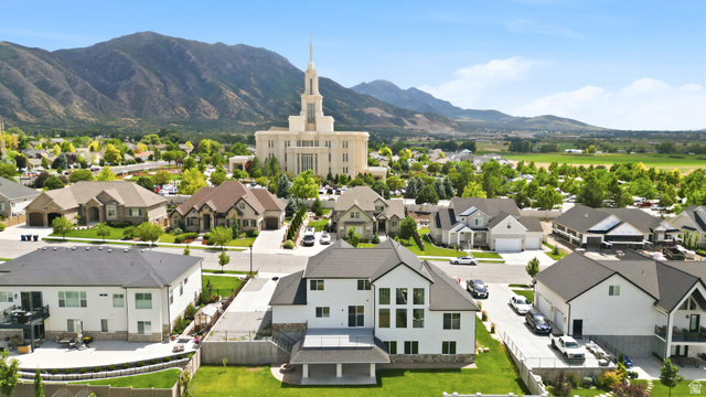 1002 West Temple Rim Lane Payson, UT 84651 - Photo 66 of 68 Expansive residential area featuring a prominent white building with a spired roof, surrounded by mature trees and mountain ranges in the background