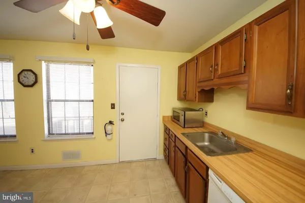 a kitchen with stainless steel appliances granite countertop a refrigerator a stove and a sink with wooden floor