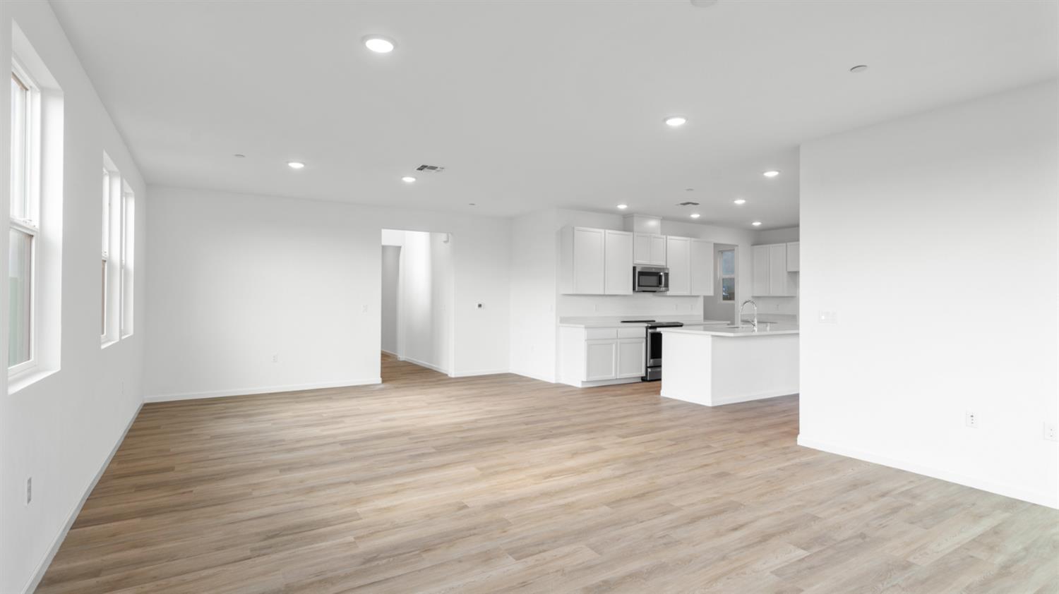 4261 Paisleyshire Way Rancho Cordova, CA 95742 - Photo 13 of 42 a view of an empty room and kitchen with wooden floor
