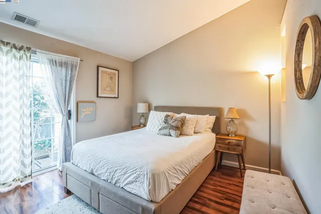 a large bed sitting in a bedroom next to a window