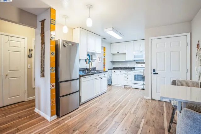 a kitchen with white cabinets and white appliances
