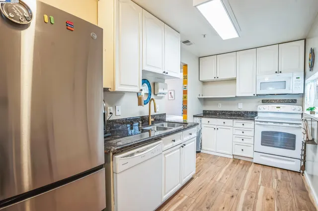 a kitchen with a white cabinets and white appliances