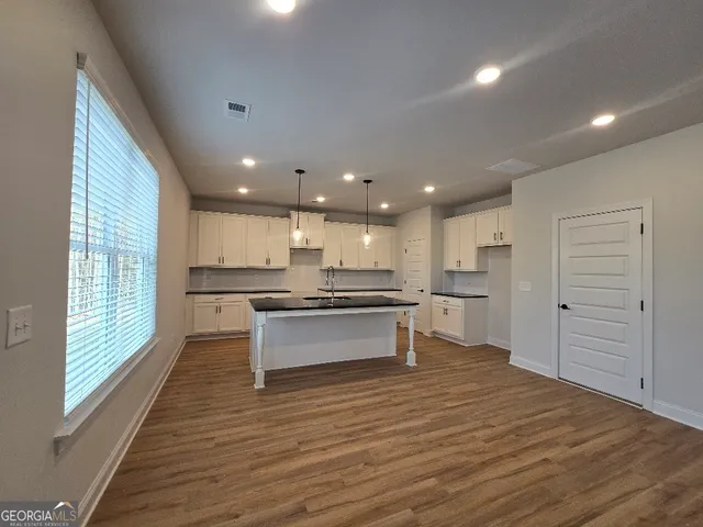a large kitchen with stainless steel appliances kitchen island a large counter top and a wooden floors