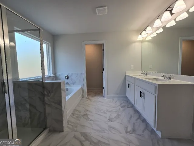 a spacious bathroom with a double vanity sink a large mirror and a bathtub