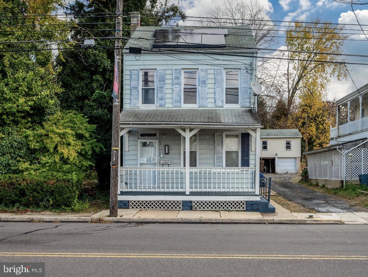 a view of a brick house with large windows and a small yard