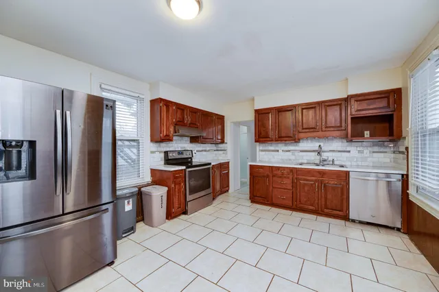 a kitchen with stainless steel appliances granite countertop a refrigerator sink and stove