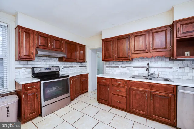 a kitchen with stainless steel appliances granite countertop wooden cabinets a stove top oven a sink and dishwasher