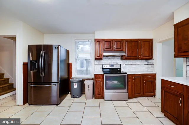 a kitchen with granite countertop a refrigerator and a stove top oven