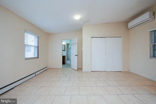 an empty room with windows and closet