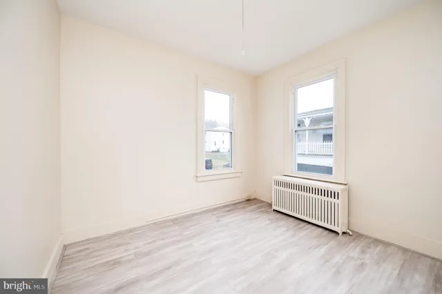 an empty room with a window and wooden floor