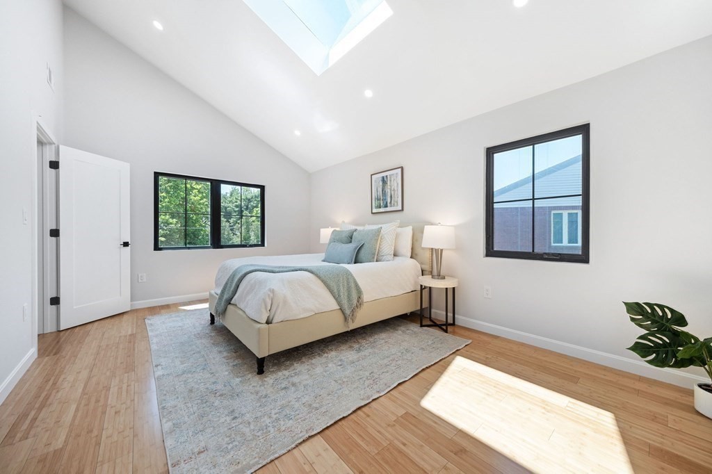 9-11 Glazer Road, Unit 11 Newton, MA 02459 - Photo 21 of 31 a bedroom with a bed lamp and a potted plant