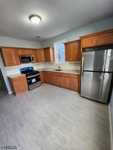 a kitchen with stainless steel appliances granite countertop a refrigerator and a stove top oven