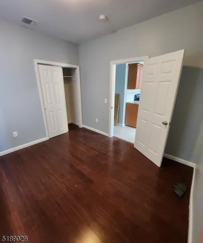 an empty room with wooden floor and cabinet