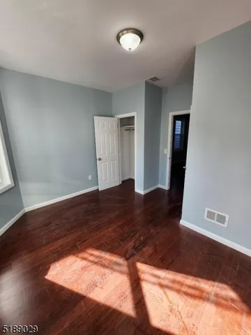 a view of a big room with wooden floor and closet