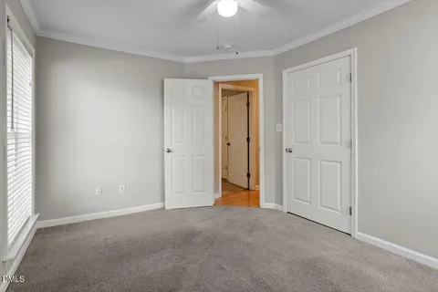 an empty room with a ceiling fan and a window