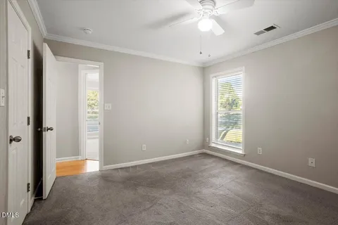 an empty room with fan and windows