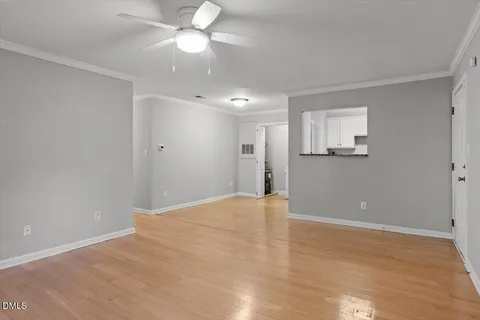 a view of an empty room with a ceiling fan and window