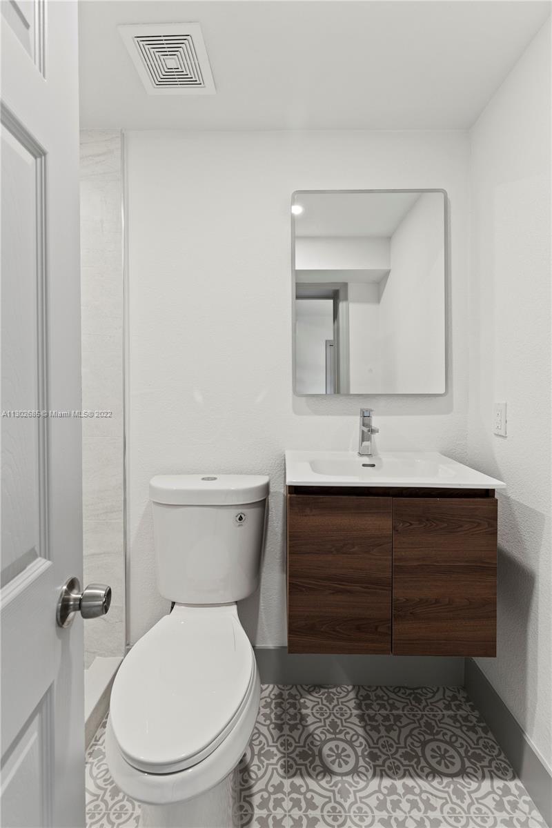 Pinewood Miami, FL 33150 - Photo 18 of 20 a bathroom with a toilet sink and mirror