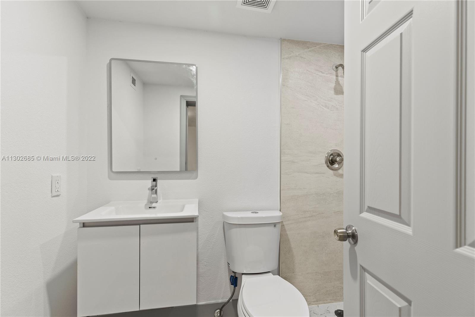 Pinewood Miami, FL 33150 - Photo 10 of 20 a bathroom with a toilet sink and mirror