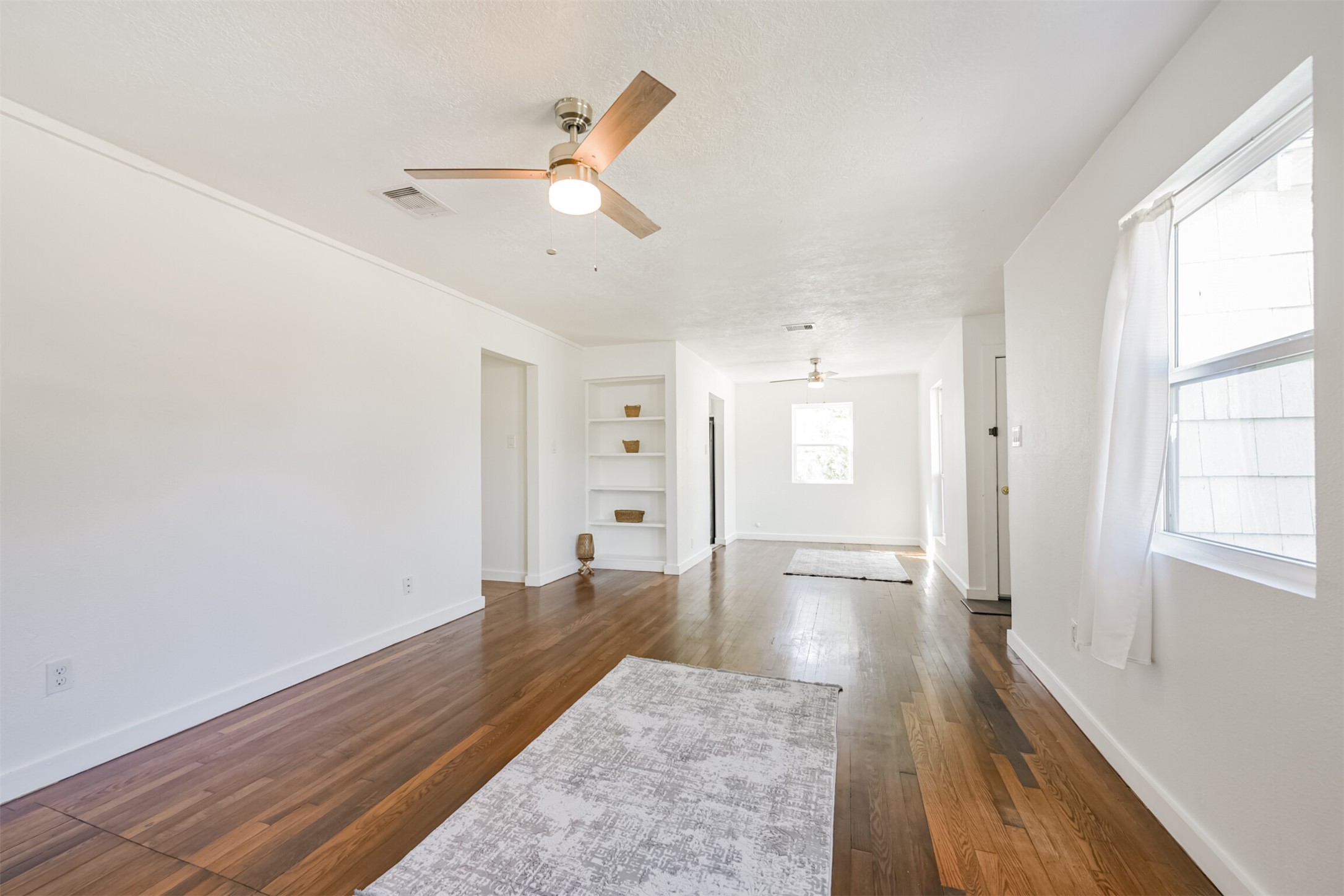 7546 Greendowns Street Houston, TX 77087 - Photo 9 of 33 wooden floor in an empty room with a window