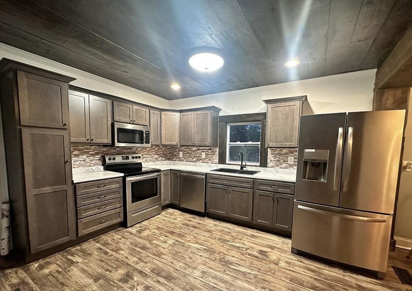 120 7th Street Calhoun, TN 37309 - Photo 5 of 17 a kitchen with stainless steel appliances granite countertop a refrigerator stove microwave and sink