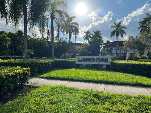 a front view of a house with a yard and potted plants