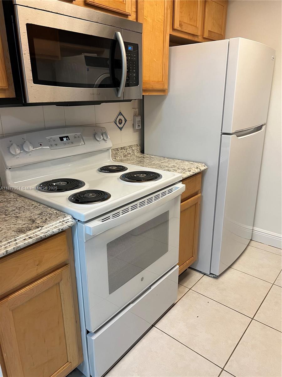 9472 Southwest 77th Avenue, Unit P3 Miami, FL 33156 - Photo 4 of 6 a kitchen with a stove microwave and refrigerator