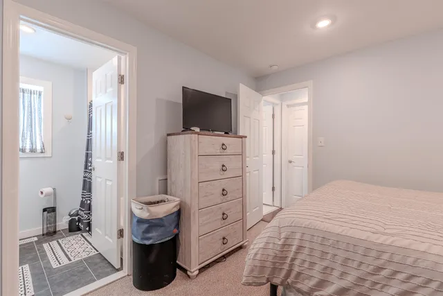 a bedroom with a dresser and a flat screen tv