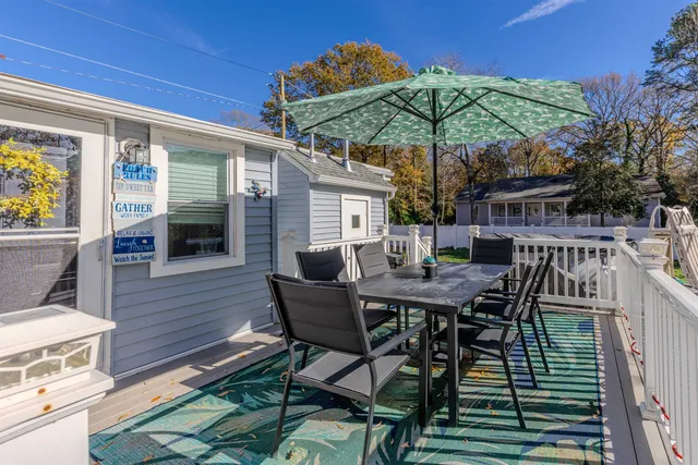 a patio with wooden floor a yard a table and chairs