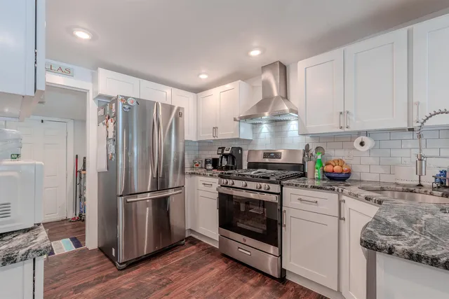 a kitchen with stainless steel appliances granite countertop a stove a refrigerator and a refrigerator