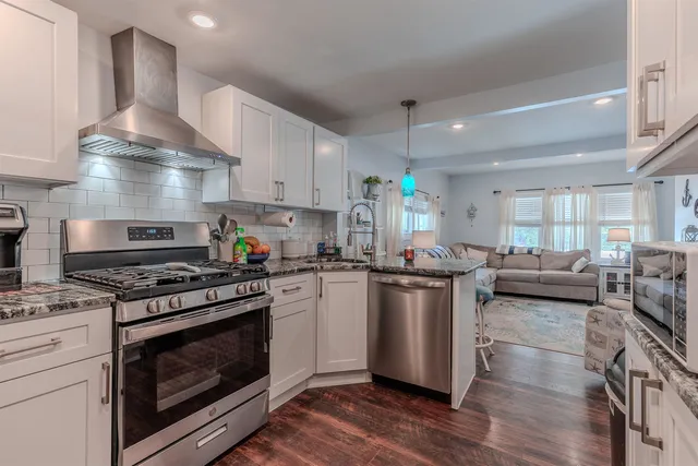 a kitchen with stainless steel appliances a stove a sink and a refrigerator