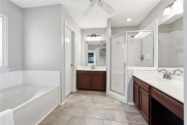 a bathroom with a tub sink shower and mirror