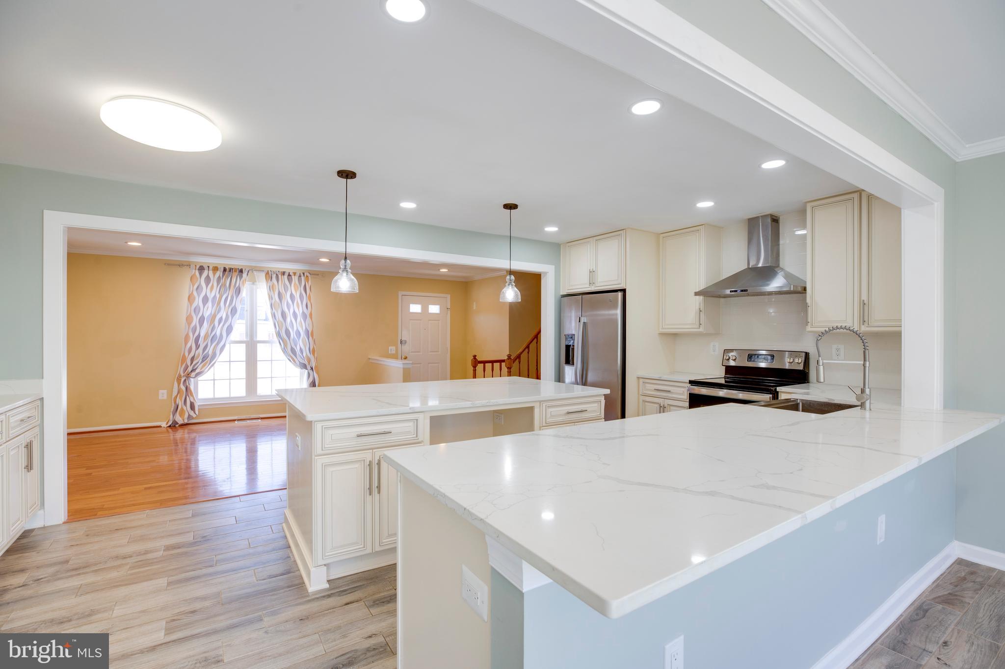 11905 Basswood Drive Laurel, MD 20708 - Photo 15 of 51 a large kitchen with kitchen island a large counter top space a sink stainless steel appliances and cabinets