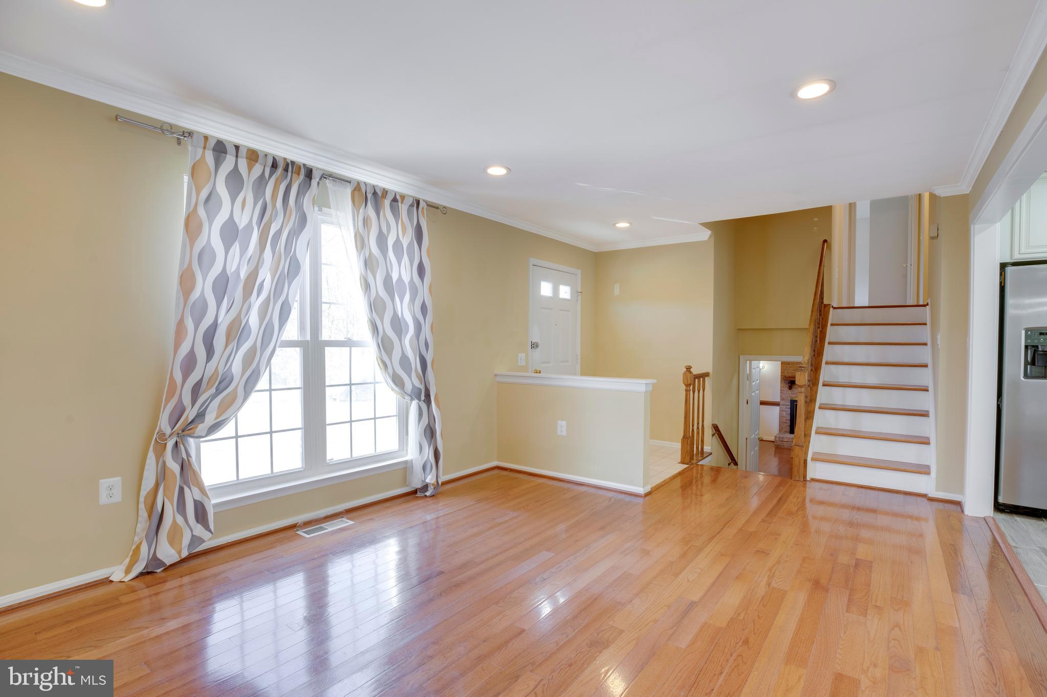 11905 Basswood Drive Laurel, MD 20708 - Photo 6 of 51 a view of an empty room with wooden floor and a window