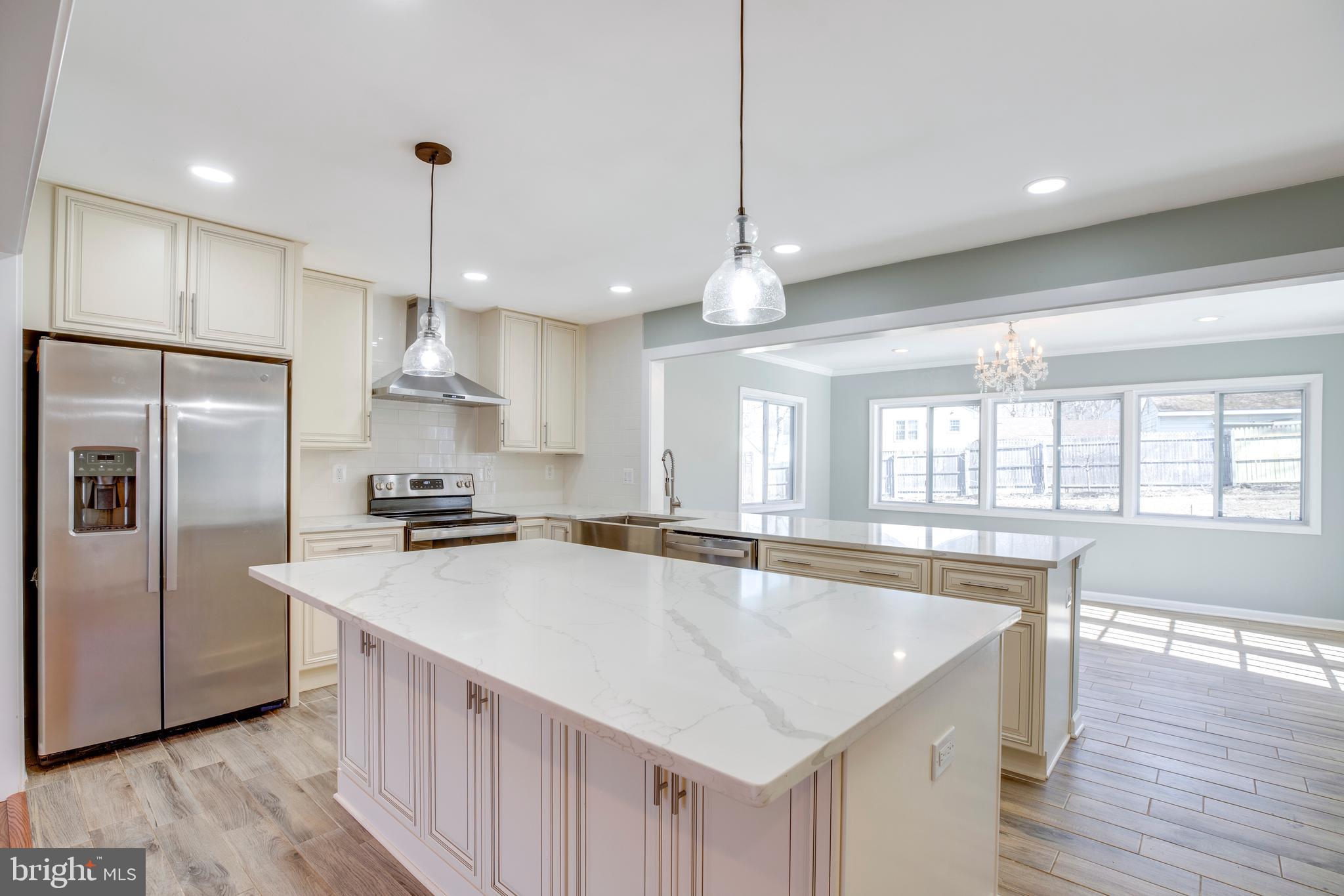 11905 Basswood Drive Laurel, MD 20708 - Photo 8 of 51 a kitchen with stainless steel appliances granite countertop a sink a stove a refrigerator a center island and wooden floor