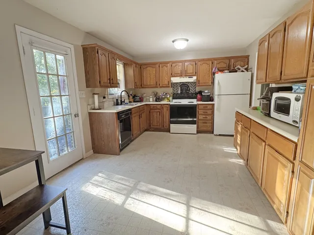 a kitchen with stainless steel appliances a refrigerator and a stove top oven