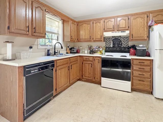 a kitchen with stainless steel appliances granite countertop a stove a sink and a refrigerator