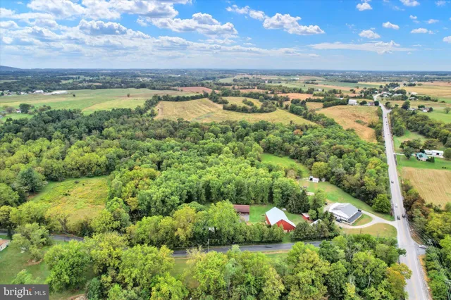 a living room with furniture a chandelier and wooden floor