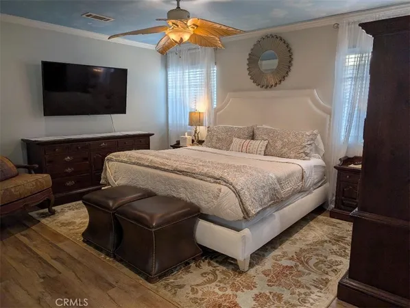 a bedroom with a bed window and a flat screen tv