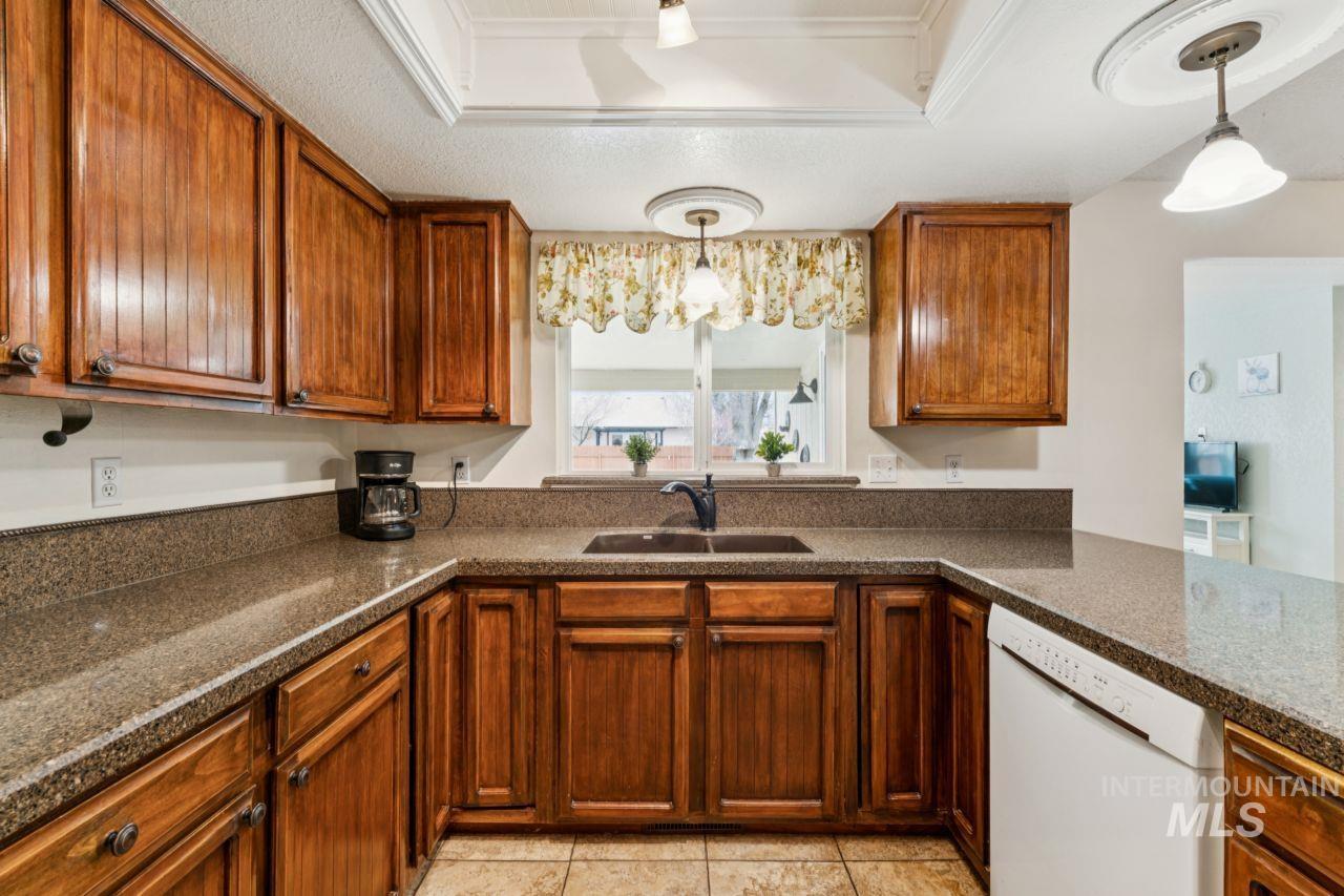 4093 North Marylebone Way Boise, ID 83713 - Photo 11 of 48 Kitchen featuring dishwasher, pendant lighting, wood finish cabinetry, and a textured ceiling