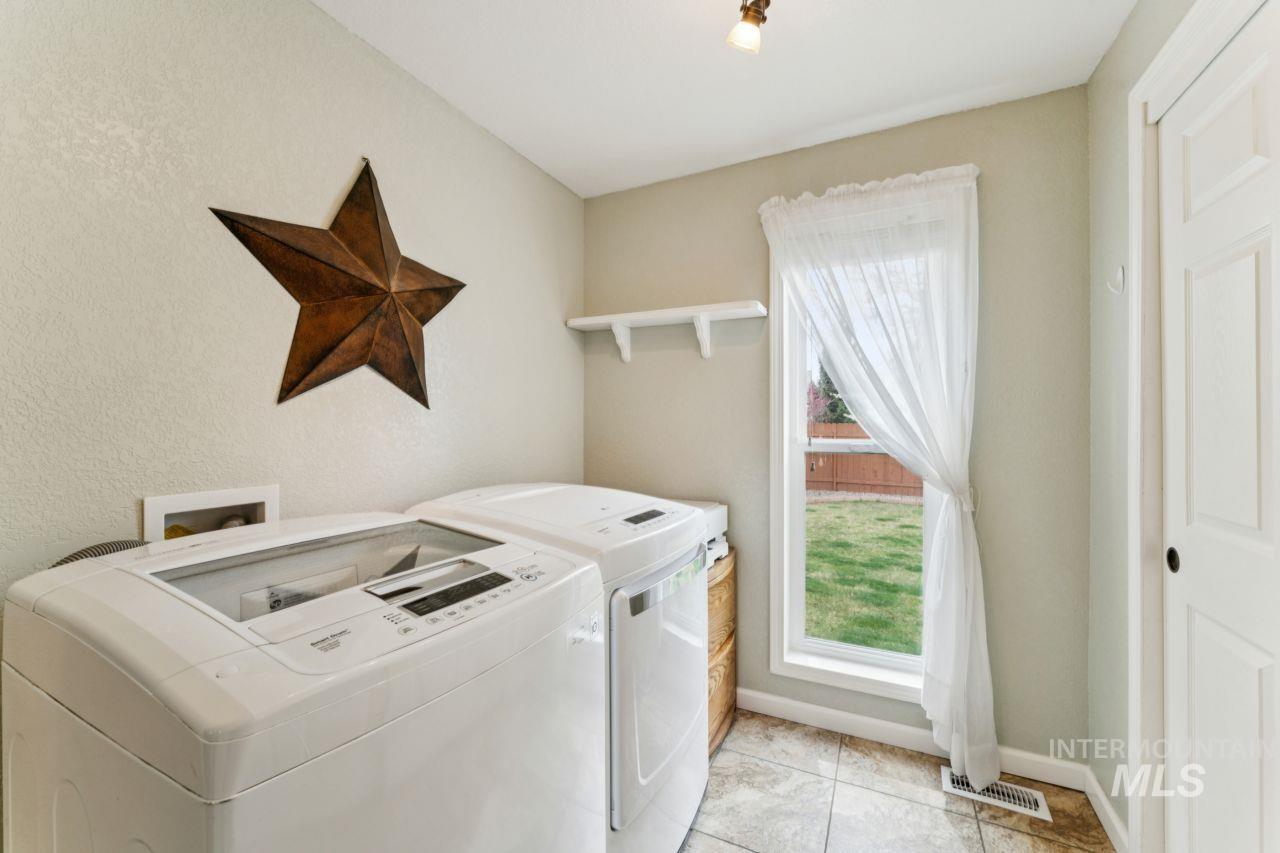 4093 North Marylebone Way Boise, ID 83713 - Photo 15 of 48 Laundry area with washer and clothes dryer, a textured wall, and light tile patterned floors