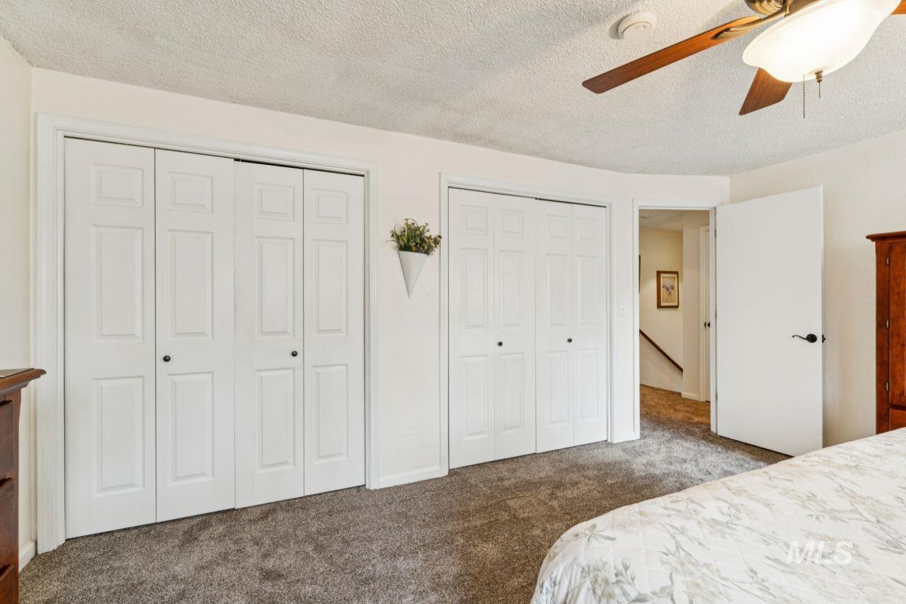 4093 North Marylebone Way Boise, ID 83713 - Photo 23 of 48 Carpeted bedroom featuring two closets, a textured ceiling, and a ceiling fan